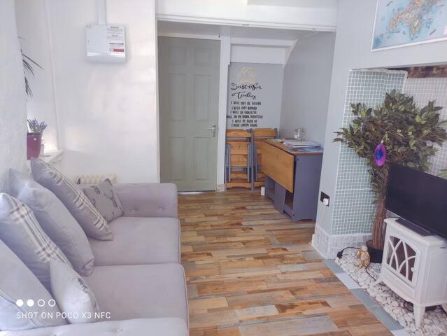 a living room with a white couch and a fireplace at Cosy Wellbeing Stays on Cornish Coast in Falmouth