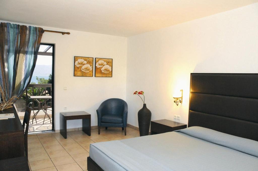 a bedroom with a bed and a chair and a table at Hersonissos Maris in Hersonissos