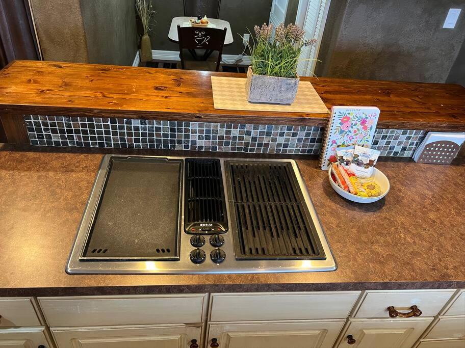 a kitchen counter with a sink and a plate of food at Entire 2br 2ba hilltop view home Sleeps 8 pets 4 acres Jacuzzi Central AC Kingbeds Free Wifi-Parking Kitchen WasherDryer Starry Terrace Two Sunset Dining Patios Grill Stovetop Oven Fridge OnsiteWoodedHiking Wildlife CoveredPatio4pets & Birds Singing! in Marble Falls