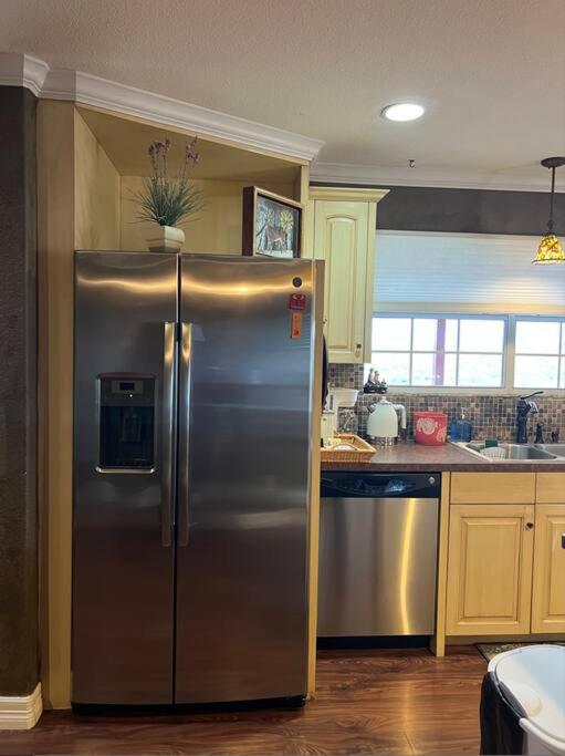 a kitchen with a stainless steel refrigerator in a kitchen at Entire 2br 2ba hilltop view home Sleeps 8 pets 4 acres Jacuzzi Central AC Kingbeds Free Wifi-Parking Kitchen WasherDryer Starry Terrace Two Sunset Dining Patios Grill Stovetop Oven Fridge OnsiteWoodedHiking Wildlife CoveredPatio4pets & Birds Singing! in Marble Falls