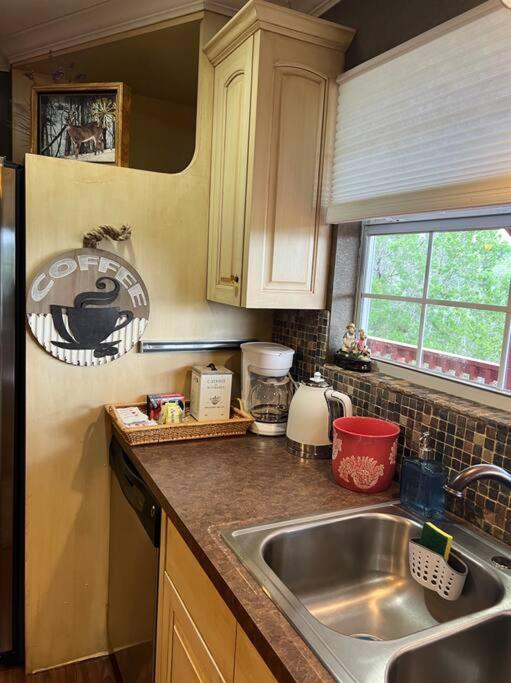 a kitchen with a sink and a counter top at Entire 2br 2ba hilltop view home Sleeps 8 pets 4 acres Jacuzzi Central AC Kingbeds Free Wifi-Parking Kitchen WasherDryer Starry Terrace Two Sunset Dining Patios Grill Stovetop Oven Fridge OnsiteWoodedHiking Wildlife CoveredPatio4pets & Birds Singing! in Marble Falls