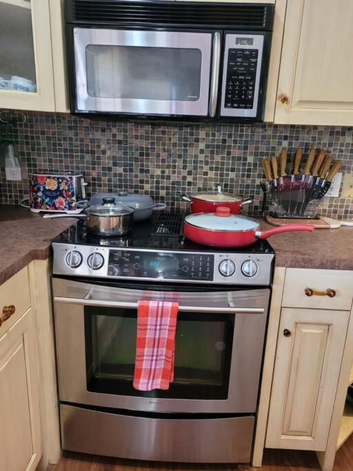 a kitchen with a stainless steel stove with a microwave at Entire 2br 2ba hilltop view home Sleeps 8 pets 4 acres Jacuzzi Central AC Kingbeds Free Wifi-Parking Kitchen WasherDryer Starry Terrace Two Sunset Dining Patios Grill Stovetop Oven Fridge OnsiteWoodedHiking Wildlife CoveredPatio4pets & Birds Singing! in Marble Falls