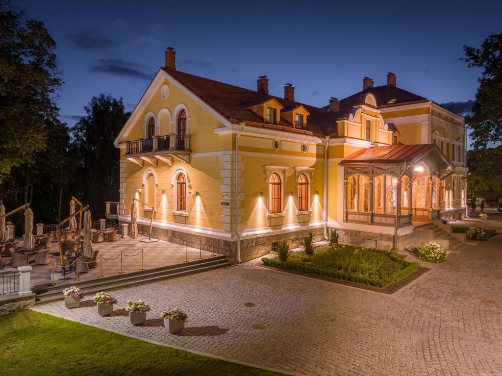 une grande maison éclairée la nuit dans l'établissement Schloss Fellin Boutique Hotel and Spa, à Viljandi