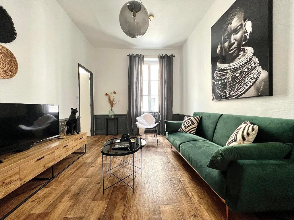 Il comprend un salon doté d'un canapé vert et d'une télévision à écran plat. dans l'établissement Bel appartement proche gare, centre ville d'Angers, à Angers