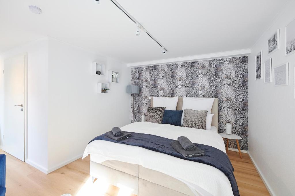 ein Schlafzimmer mit einem großen Bett und einer Wand in der Unterkunft Wohnträumerei Petit - Stilvoll eingerichtetes und ruhiges Design Apartment in Göttingen