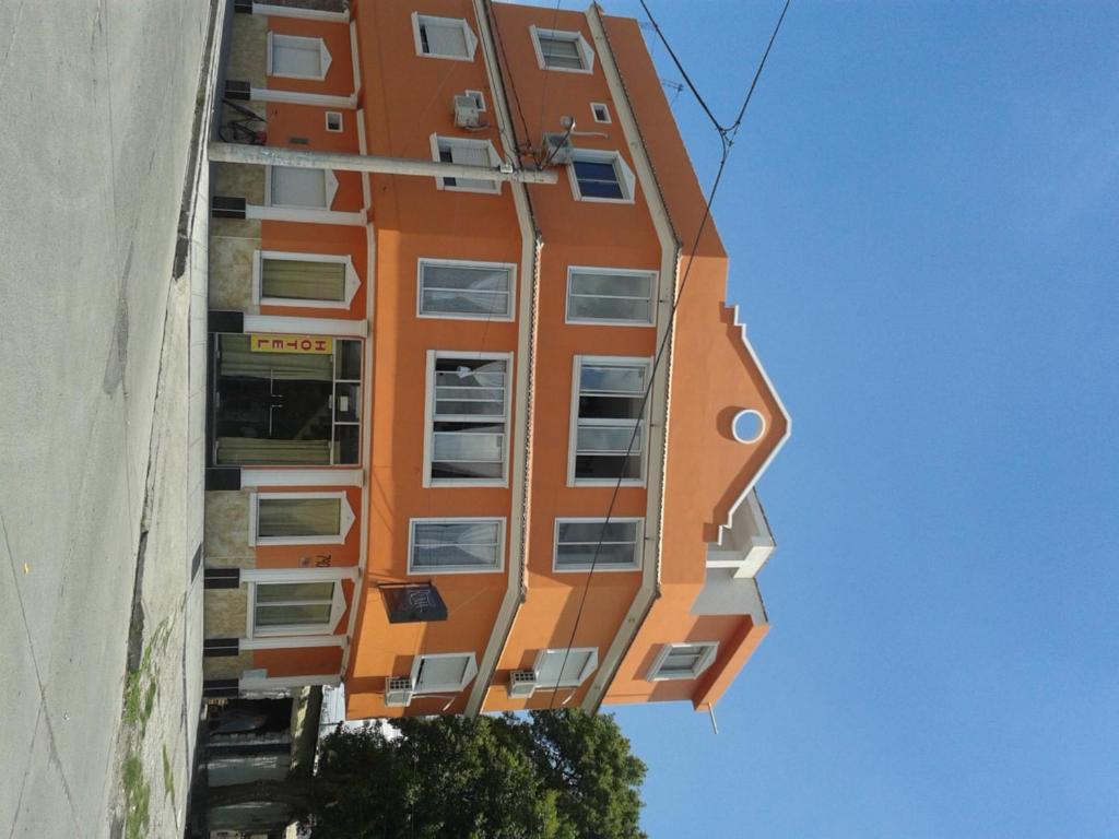 an orange building with windows on the side of a building at Hotel Ruma in Salta