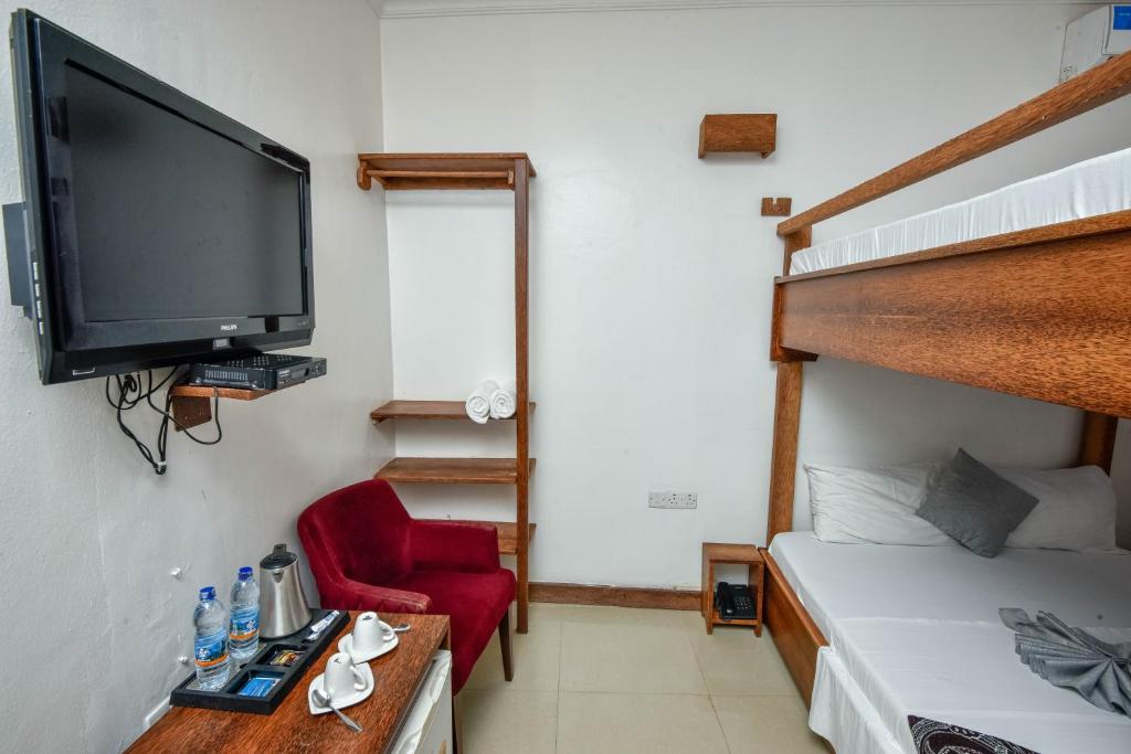 Postel nebo postele na pokoji v ubytování Kuti Hotel Stone Town
