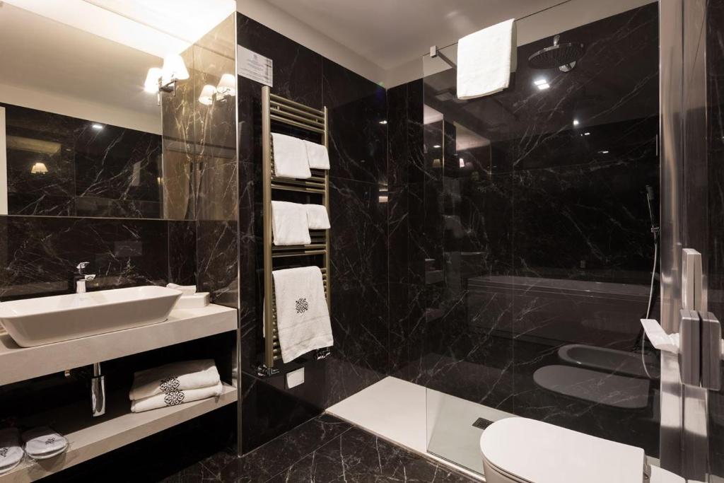 a black bathroom with a sink and a shower at Mediterraneo Emotional Hotel & Spa in Santa Margherita Ligure