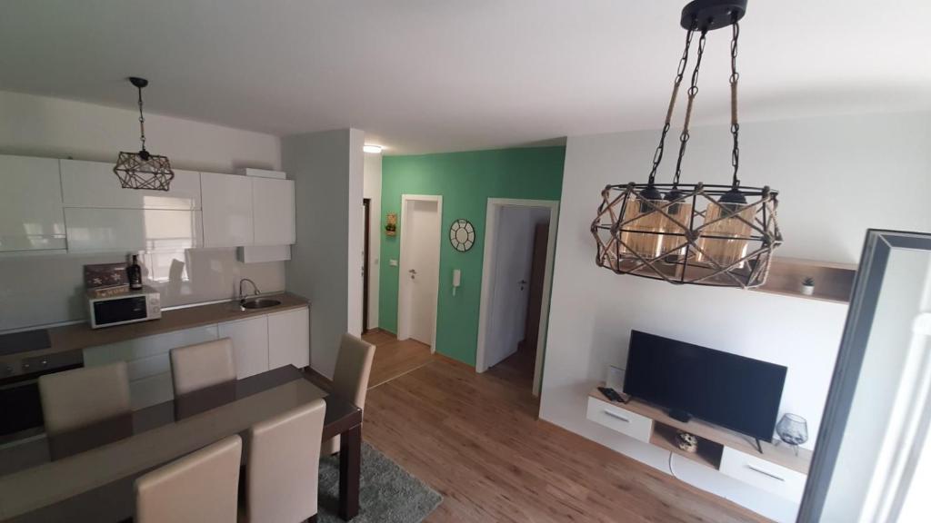a kitchen and a living room with a tv in a room at Apartman SATO in Brčko