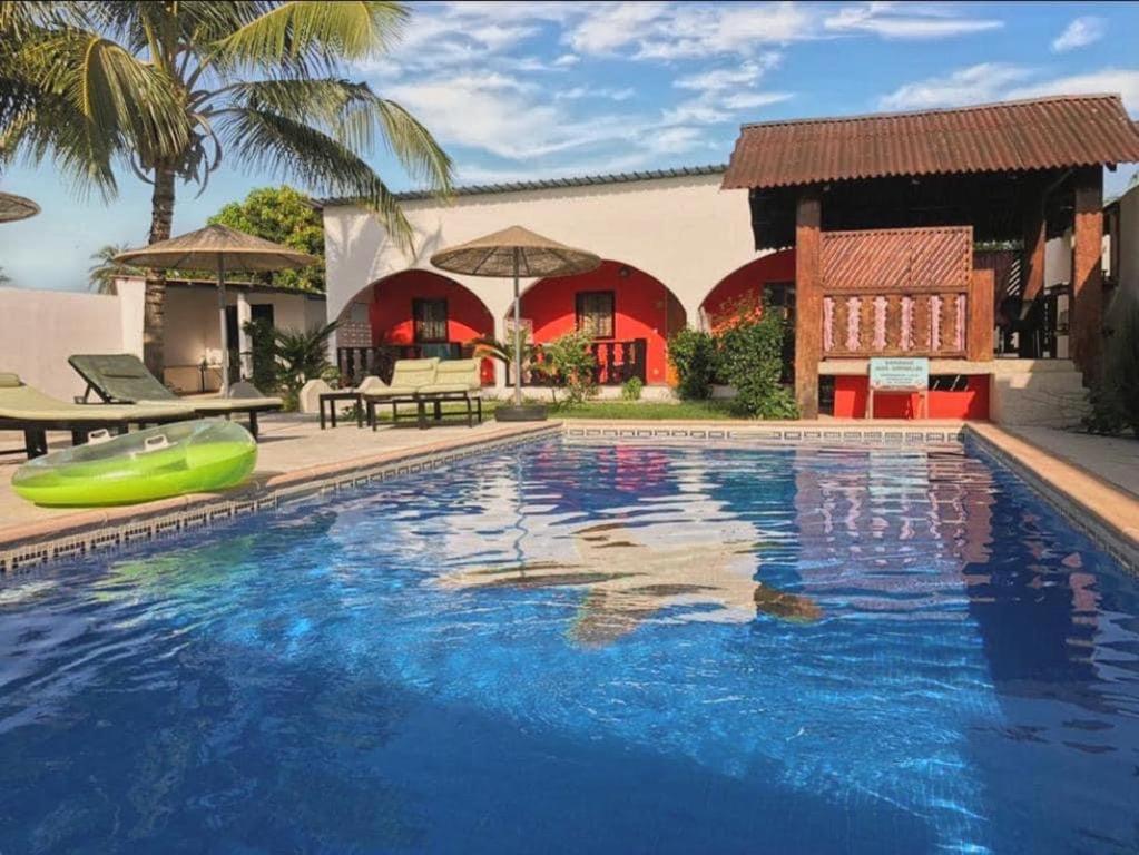 a swimming pool in front of a house at VilladesPêcheurs Beach in Cap Skirring