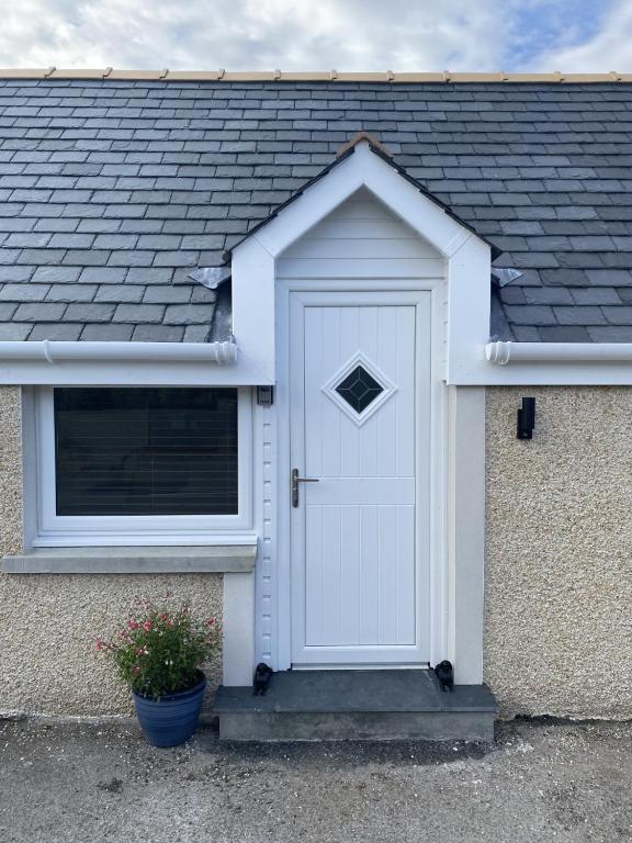 una puerta blanca en el lateral de una casa en 12 North Street, en Sandwick