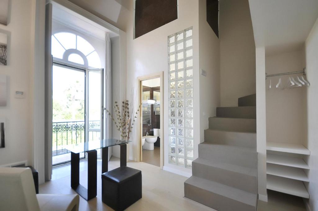 un pasillo con escaleras, una mesa y una ventana en Villa Battista, en Ercolano