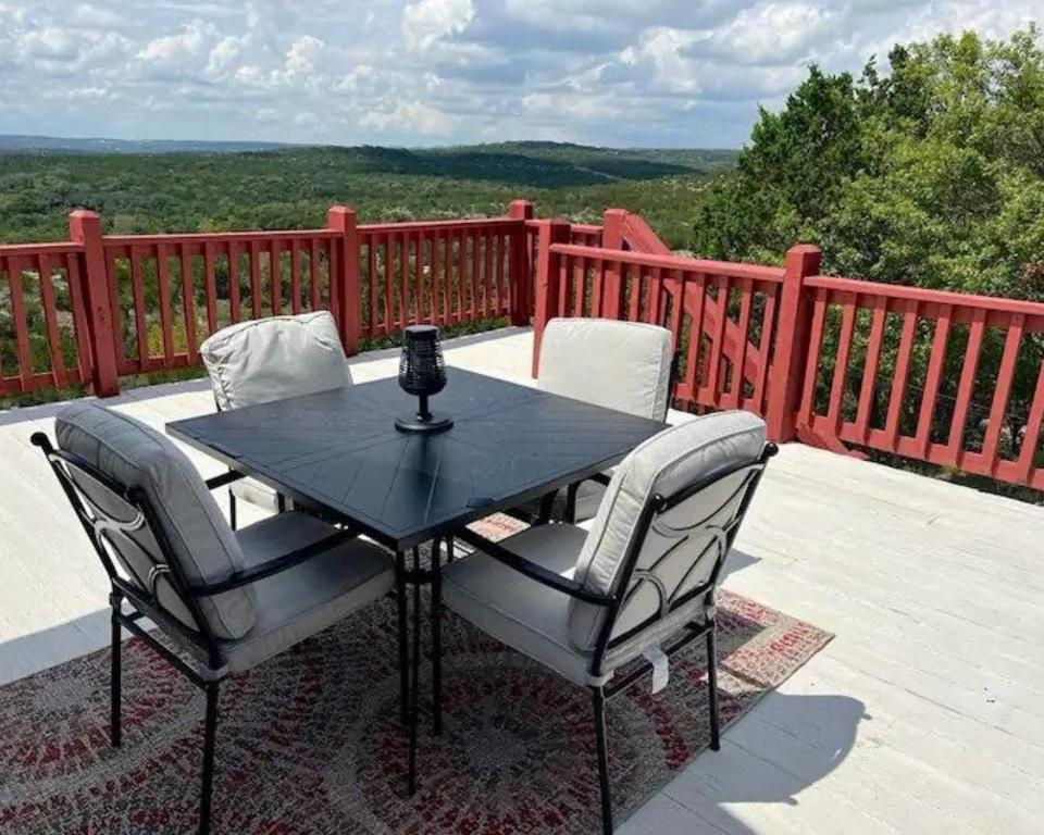 a table and chairs on a patio with a view at entire home Hilltop View 4 serene acres 2br 2ba Sleeps 7, Jacuzzi, Ctrl AC, Kingbeds, Free Wifi-Parking, Pets, Full Kitchen, WasherDryer, Starry Terrace 2 Scenic Sunset Dining Patios Grill Stovetop Oven Fridge OnsiteWoodedHiking Wildlife CoveredPatio4pets in Marble Falls