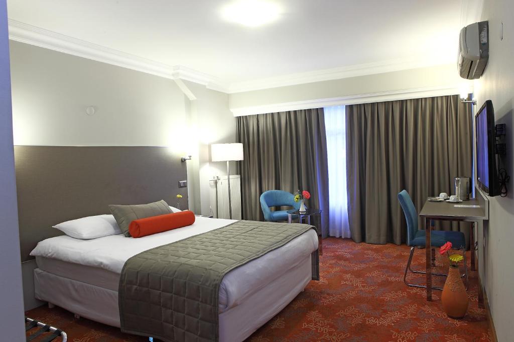マニサにあるArma Hotelのベッドとテレビが備わるホテルルームです。