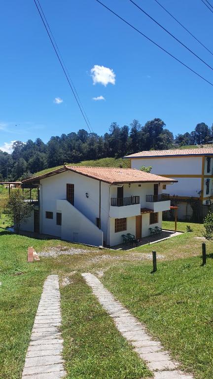 a white building with a pathway leading to it at Casa Lucía - Guatapé in Guatapé