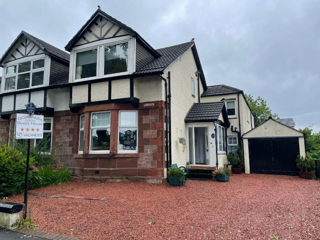 a house with a driveway in front of it at Gowanlea Guest House in Balloch