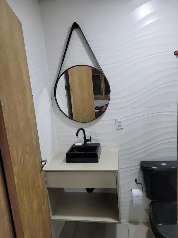 ein Badezimmer mit Waschbecken und Spiegel in der Unterkunft Novo lar Garopaba Terraço in Garopaba