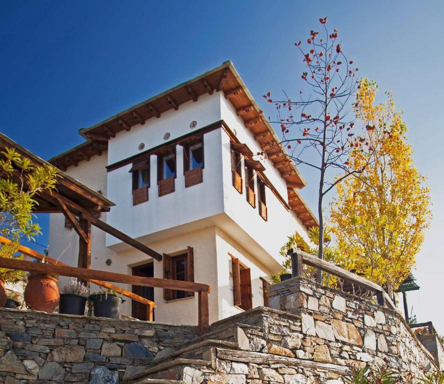 una casa en la parte superior de una pared de piedra en Pelion Homes, en Agios Georgios Nilias