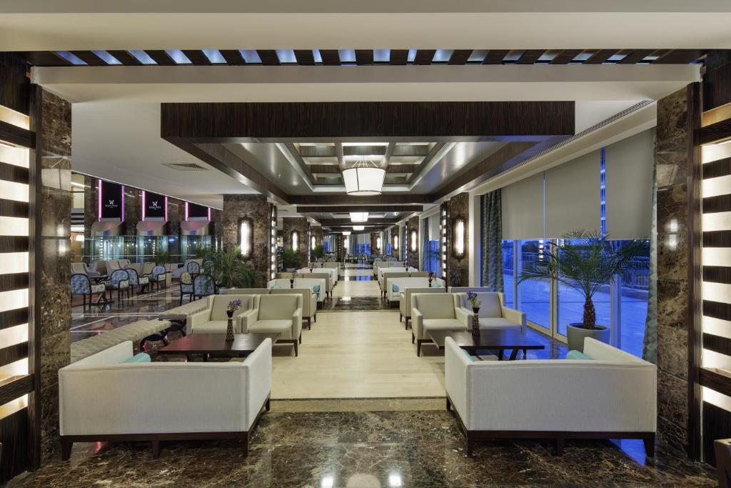 a lobby of a hotel with couches and tables at Liberty Hotels Lara in Lara