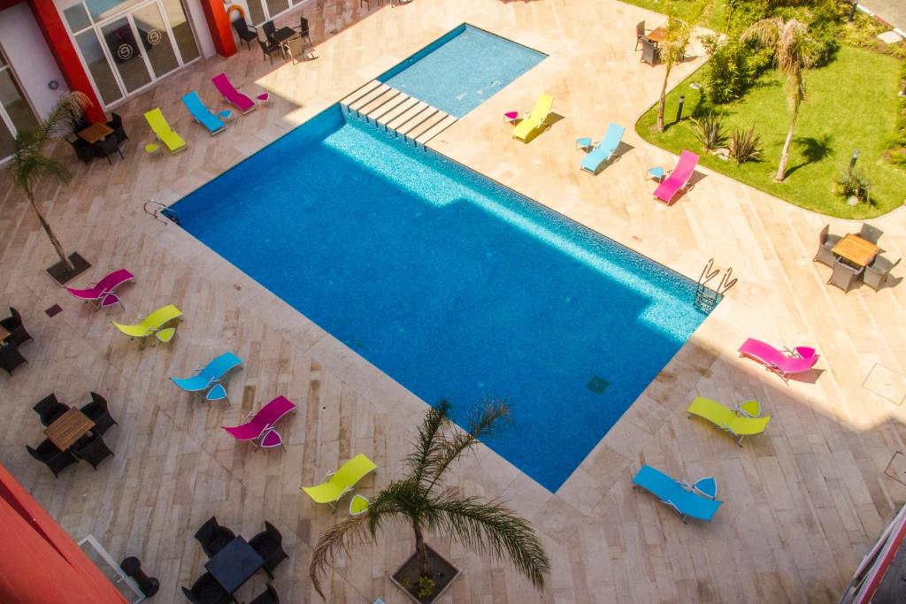 una vista sul soffitto di una piscina con sedie colorate di Ramada Encore By Wyndham Tangier a Tangeri