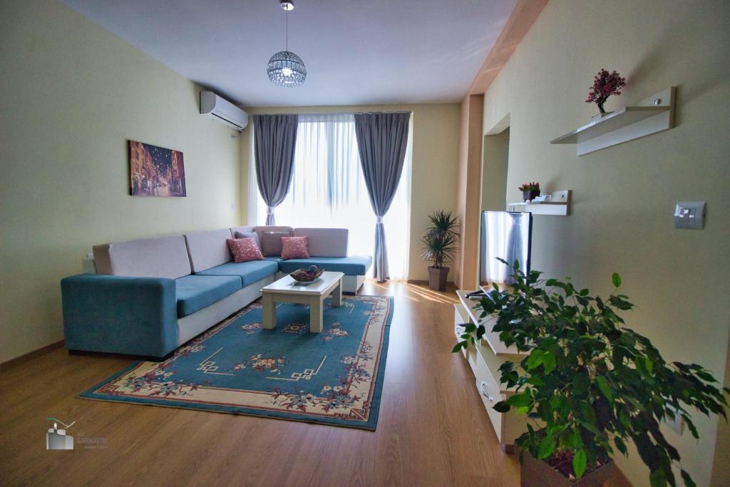 a living room with a blue couch and a table at DAI Apartments in Gjirokastër