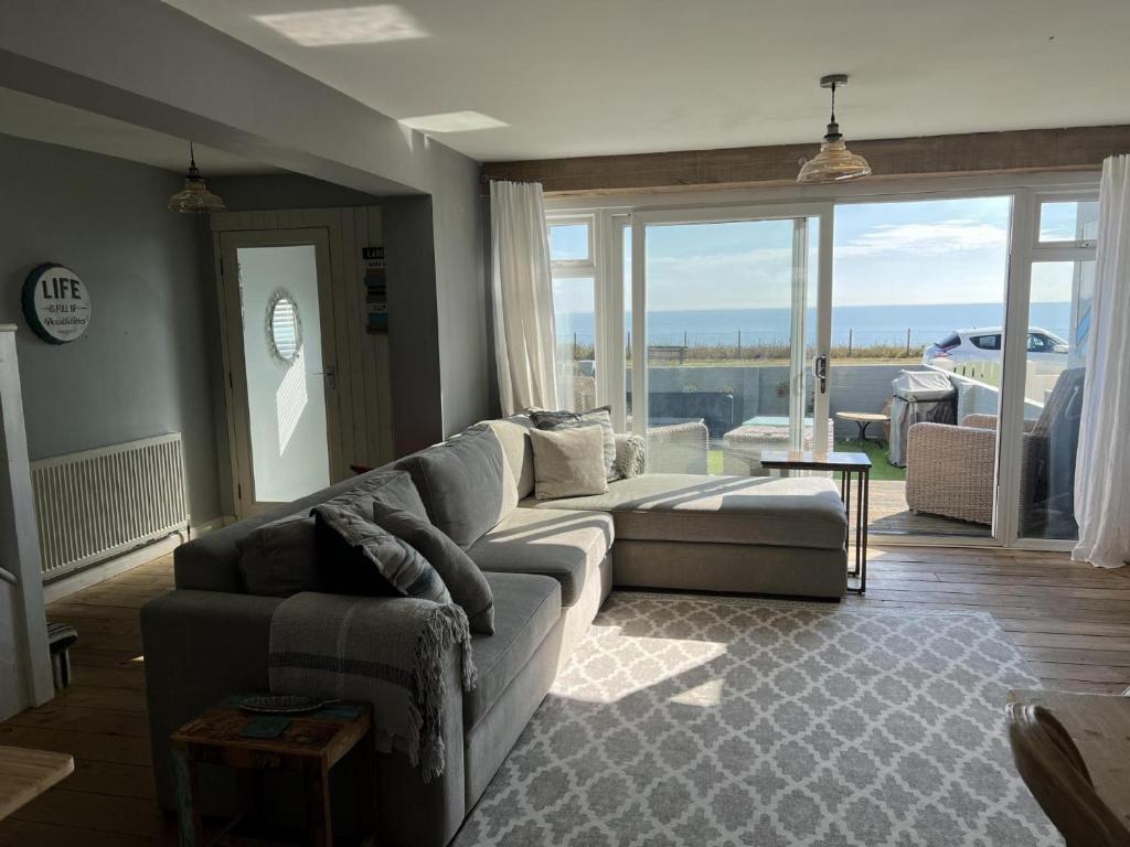 a living room with a couch and a large window at Sea Facing 2BD Terraced Home - Peacehaven in Peacehaven