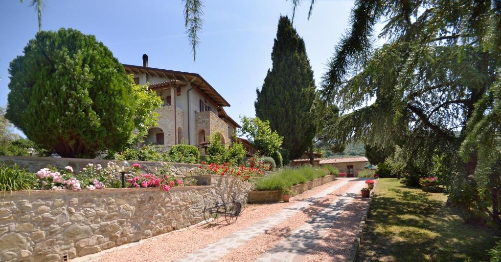 un jardín con una pared de piedra y una casa en Agriturismo San Severo, en Passignano sul Trasimeno