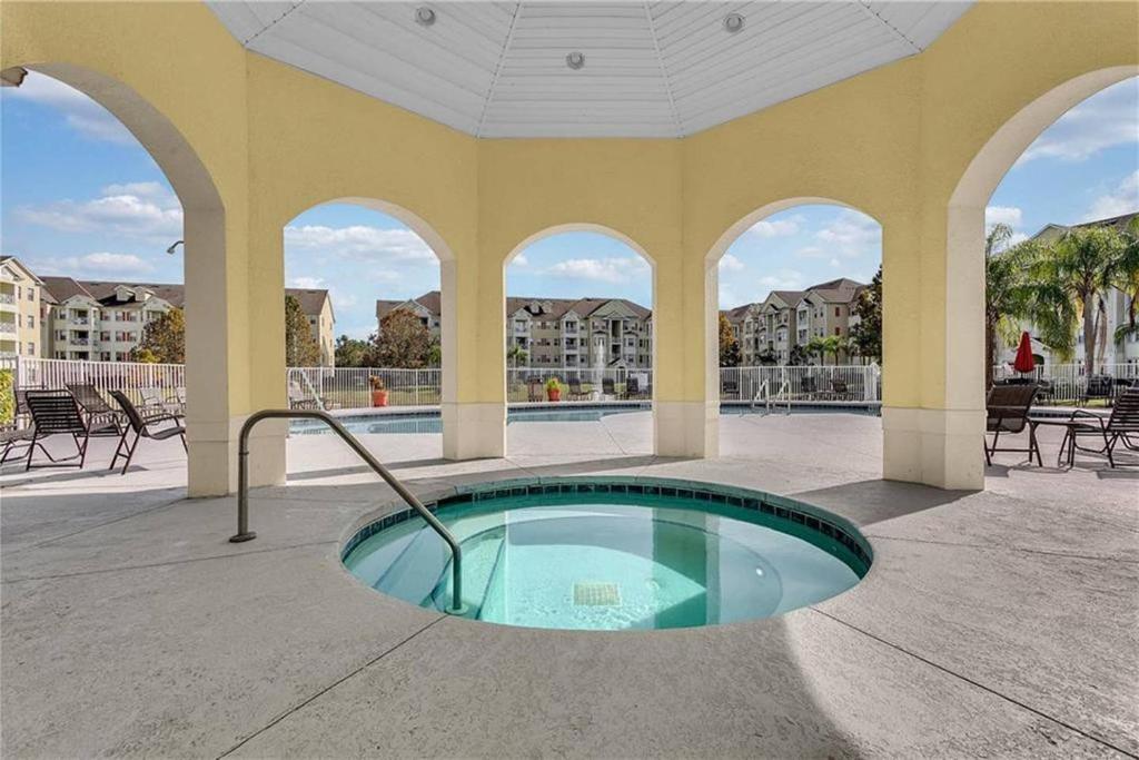 a swimming pool with a hot tub in a building at COZY Condo - Perfect Location Close to Disney in Kissimmee