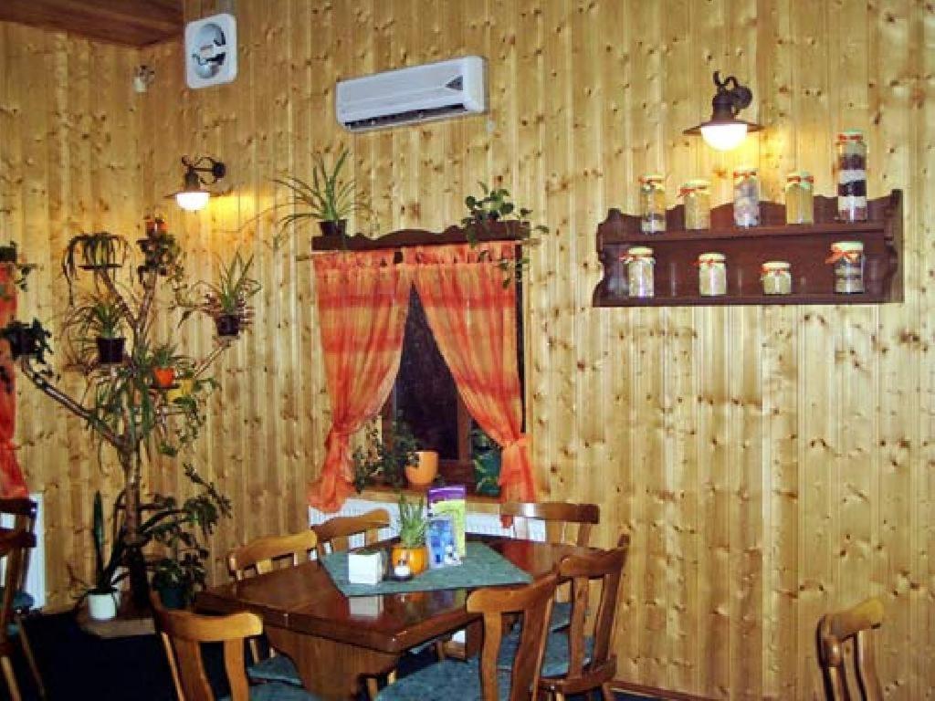 ein Esszimmer mit einem Tisch mit Stühlen und einem Fenster in der Unterkunft Restaurace a Penzion u Vladaru in Mikulášovice