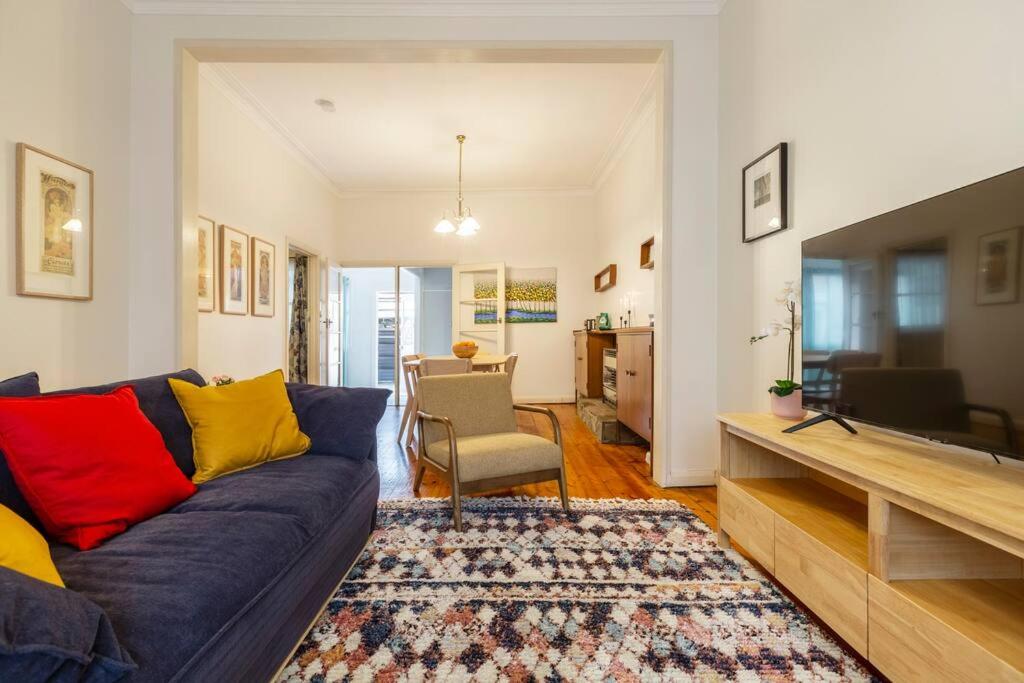 a living room with a blue couch and yellow and red pillows at Comfortable Richmond home - Melbourne’s best location in Melbourne