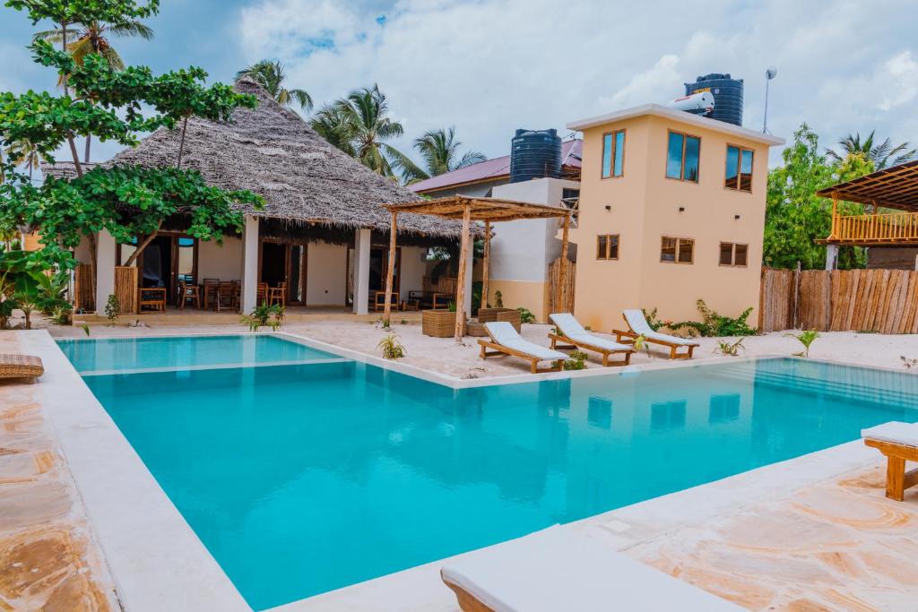 une villa avec une piscine et une maison dans l'établissement Mkunguni Villas, à Bwejuu