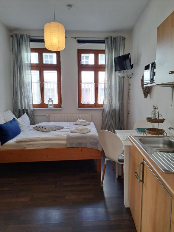 ein kleines Schlafzimmer mit einem Bett und einer Küche in der Unterkunft Altstadtcafé und Pension in Havelberg