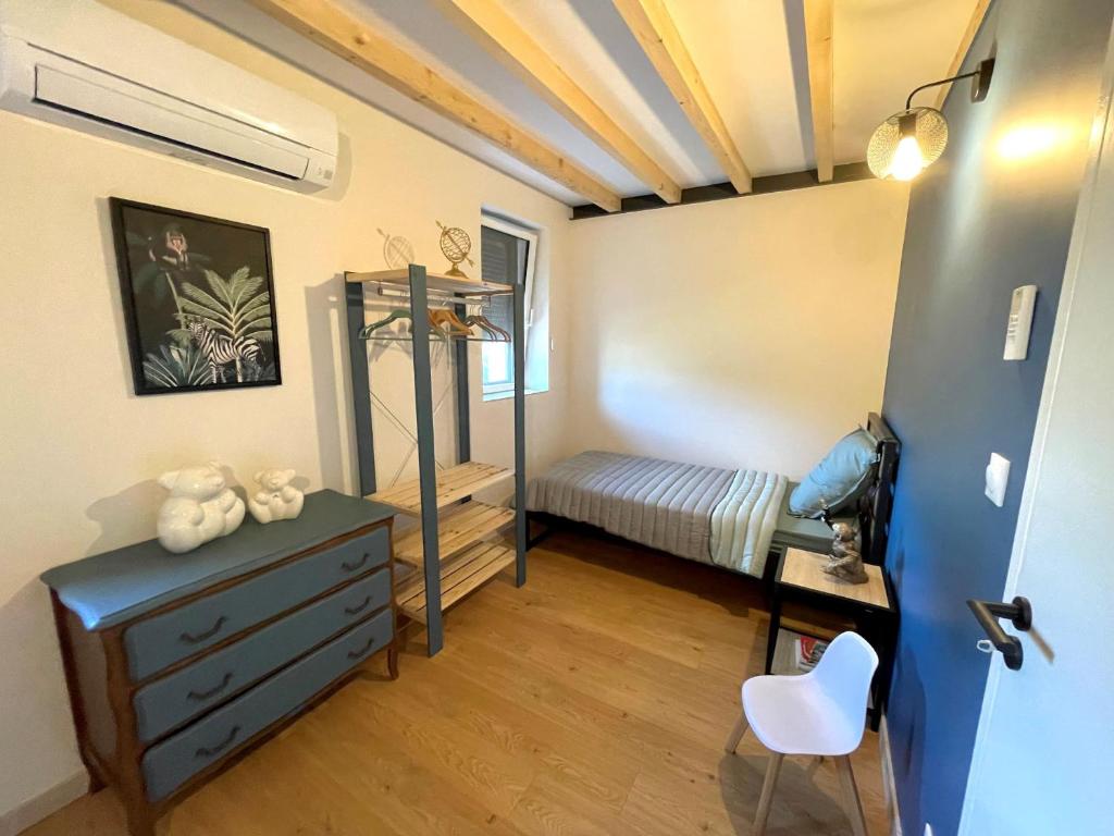 a room with a dresser and a bed in it at Meublé de tourisme 4 étoiles Logis Riquet proche de Carcassonne in Caux-et-Sauzens