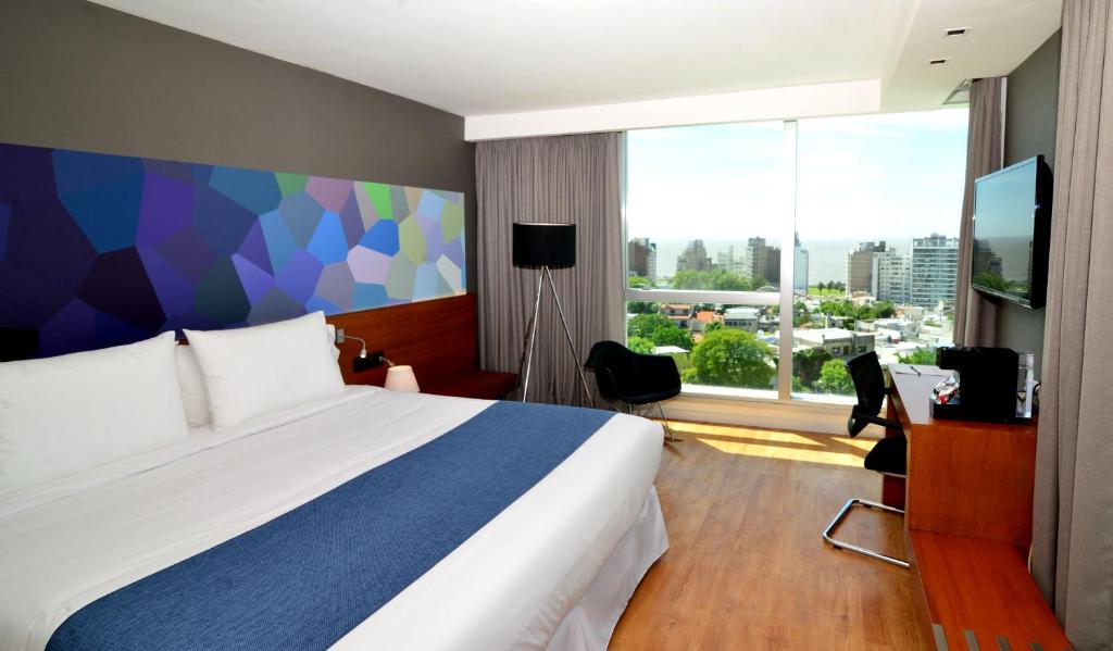 a hotel room with a bed and a large window at BIT Design Hotel in Montevideo