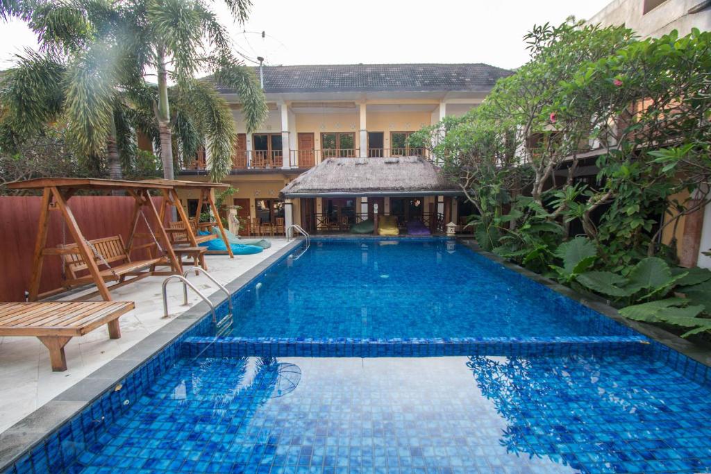 a large blue swimming pool in front of a building at Central Inn Senggigi in Senggigi