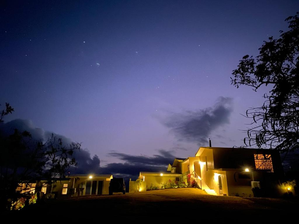 Una casa iluminada por la noche con el cielo en Lejos Eco Retreat, en Vieques