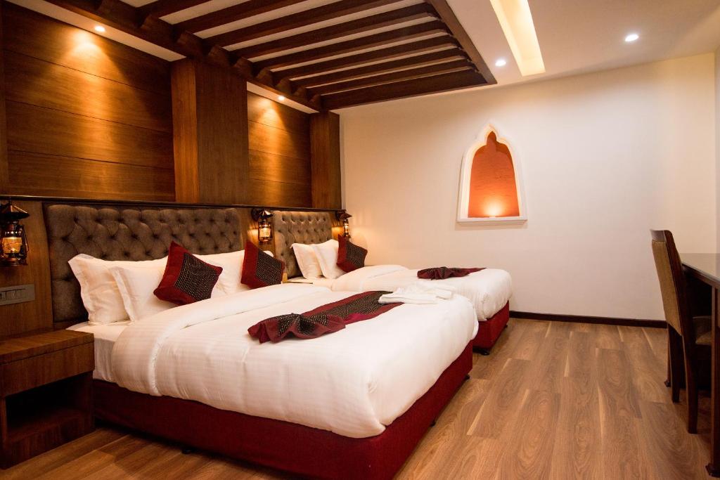 a hotel room with two beds with white sheets at Everest Boutique Hotel in Kathmandu