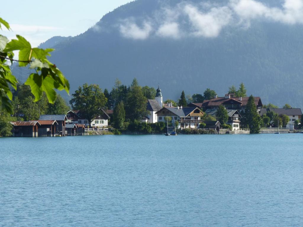 einem See mit Häusern und einem Berg im Hintergrund in der Unterkunft Walchensee-Idyll in Walchensee