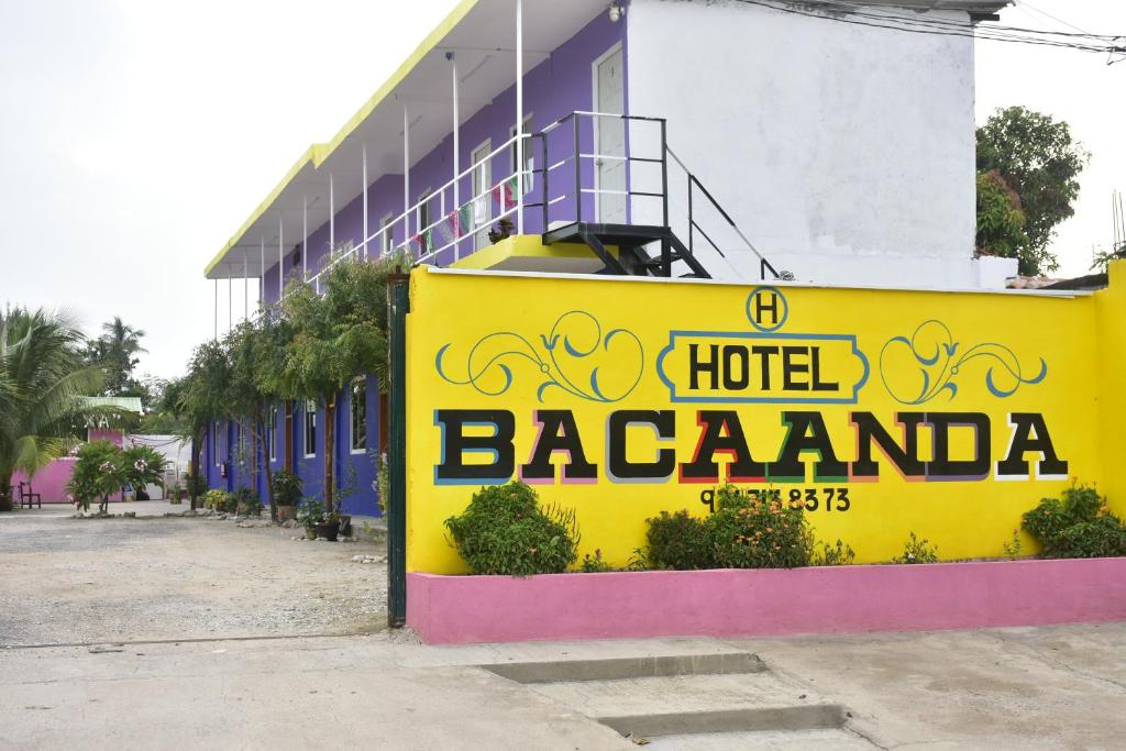 een geel hotelbord voor een gebouw bij Hotel Bacaanda 