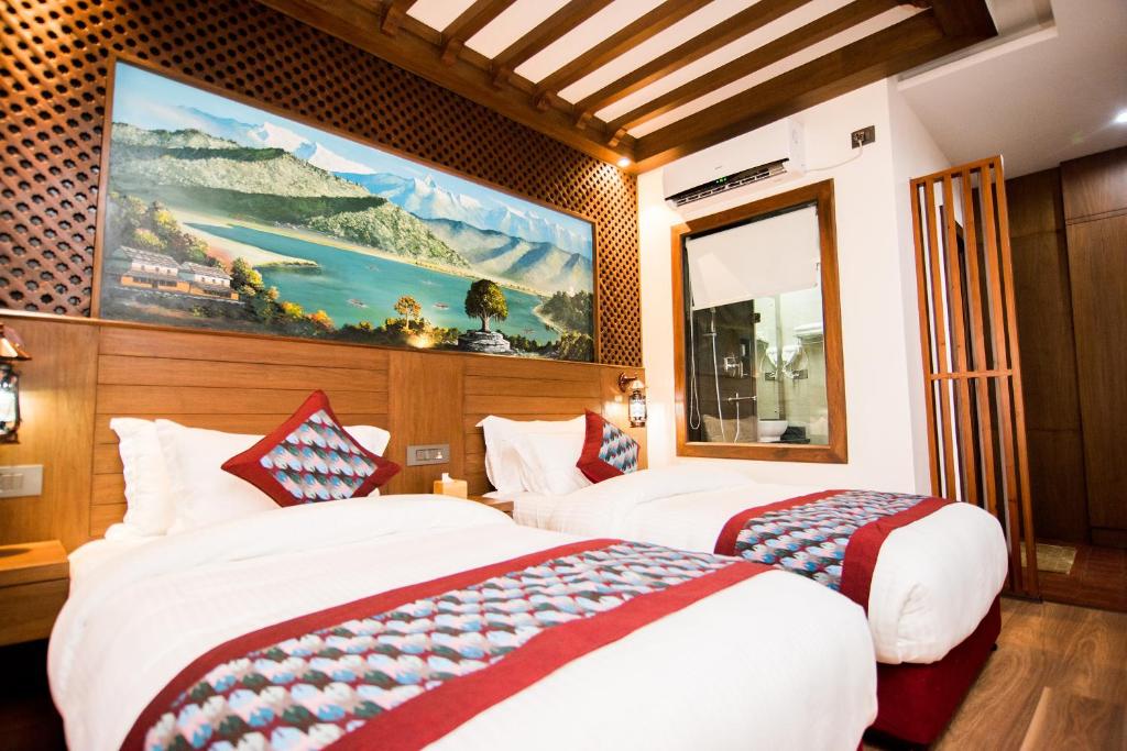 a hotel room with two beds and a painting on the wall at Everest Boutique Hotel in Kathmandu