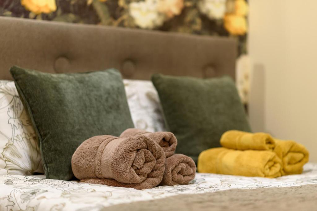 un asciugamano seduto sopra un letto con cuscini di Здаються в оренду подобово АПАРТАМЕНТИ ZONEofCOMFORT-1 Поруч з центром міста, затишні та комфортні для проживання, як вдома a Černivci