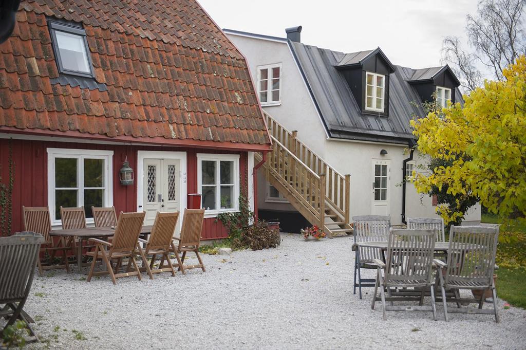 a house with a porch and a bench in front of it at Mullbärsgårdens Bed and Breakfast in Visby
