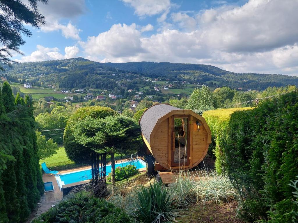 uma casa de madeira redonda com uma piscina num jardim em Urlopowa Chata em Targanice