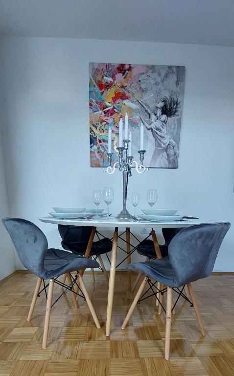 a dining room table with chairs and a painting on the wall at DITA Osijek, centar grada in Osijek