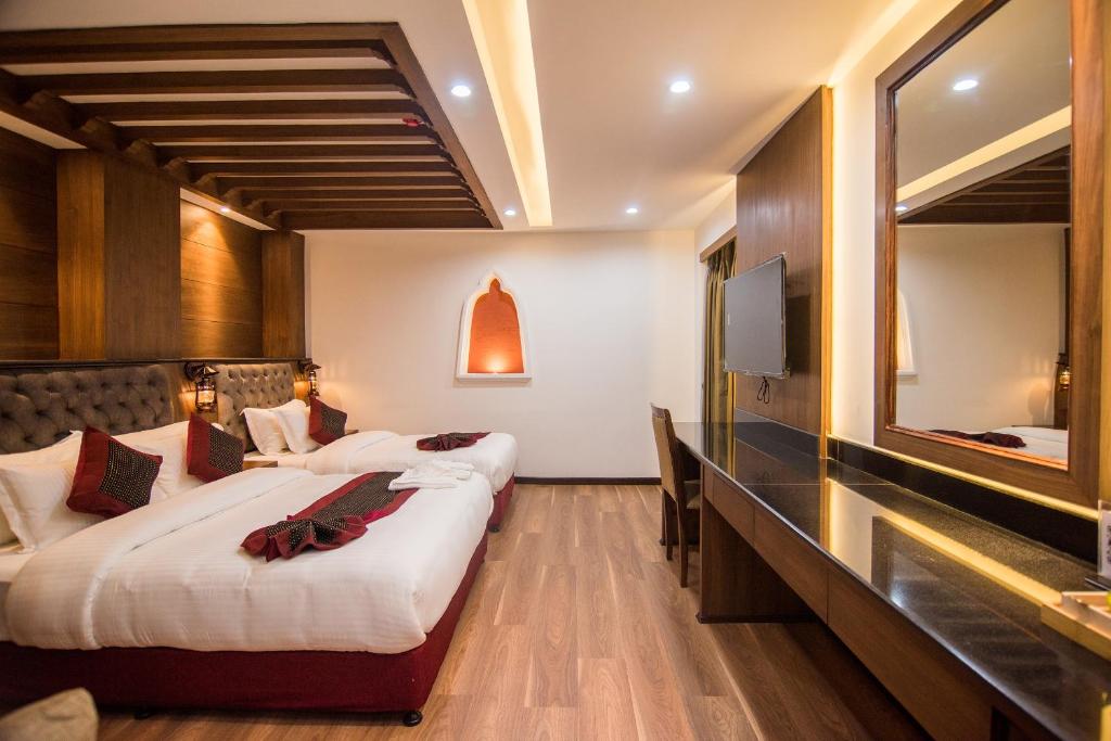 a hotel room with two beds and a mirror at Everest Boutique Hotel in Kathmandu
