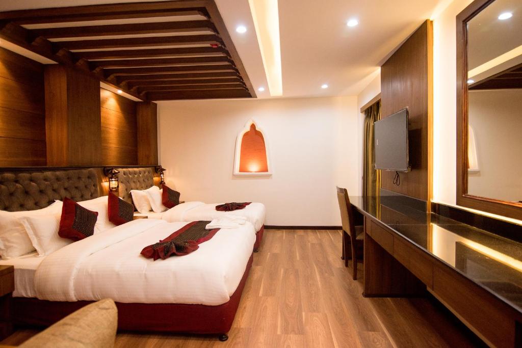 a hotel room with two beds and a flat screen tv at Everest Boutique Hotel in Kathmandu