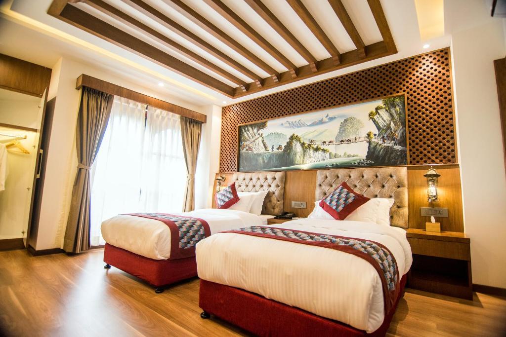 a hotel room with two beds and a painting on the wall at Everest Boutique Hotel in Kathmandu