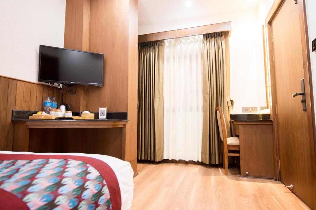 a hotel room with a bed and a flat screen tv at Everest Boutique Hotel in Kathmandu