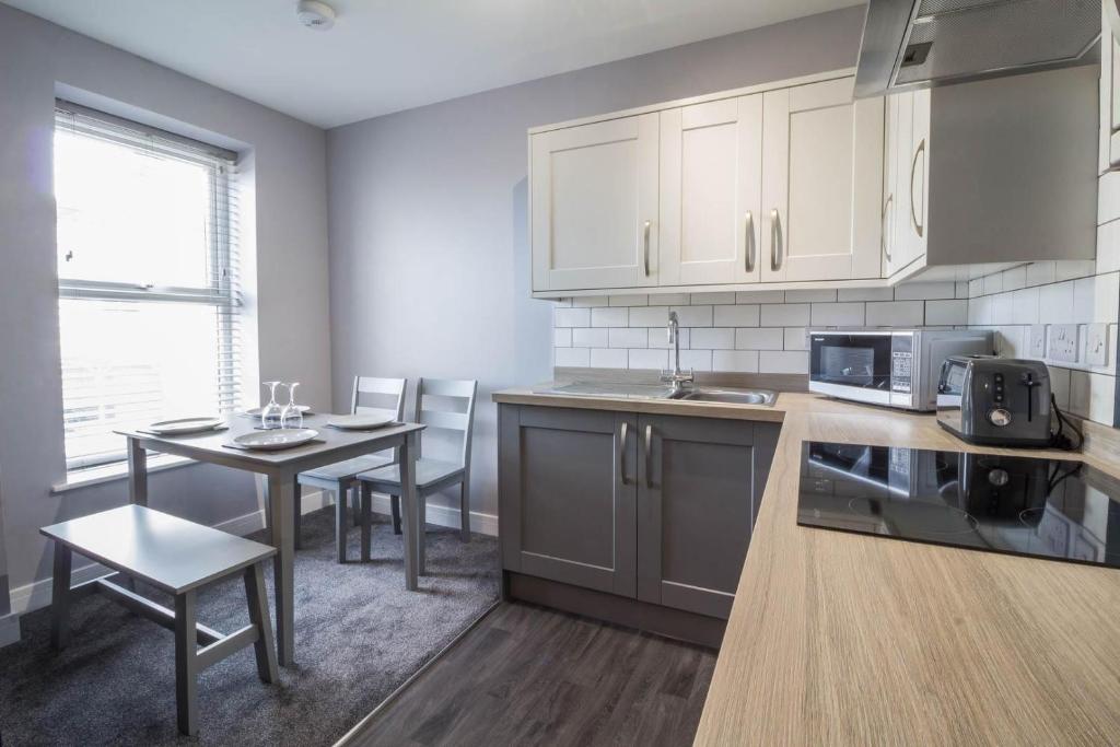 a kitchen with a table and a dining room at Beautiful 4 Berth Seaside Apartment In Great Yarmouth, Norfolk Ref 99006s in Great Yarmouth