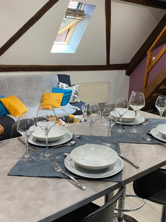 una mesa con platos y copas de vino. en Gîte du Figuier 4 à 6 personnes Sélestat Centre-Alsace en Sélestat
